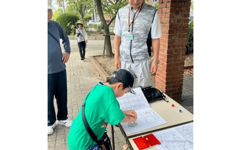 楽しそうにスタンプを押す子供を見守る弊社社員